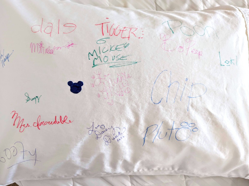 White pillowcase with colorful Disney character autographs
