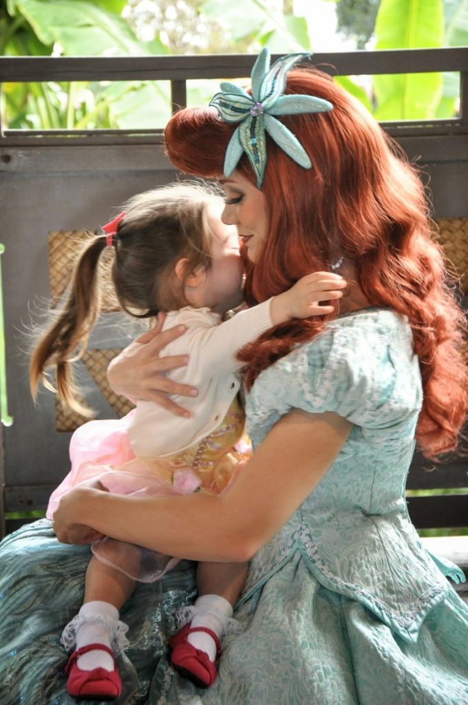 A toddler hugs Ariel at Magic Kingdom