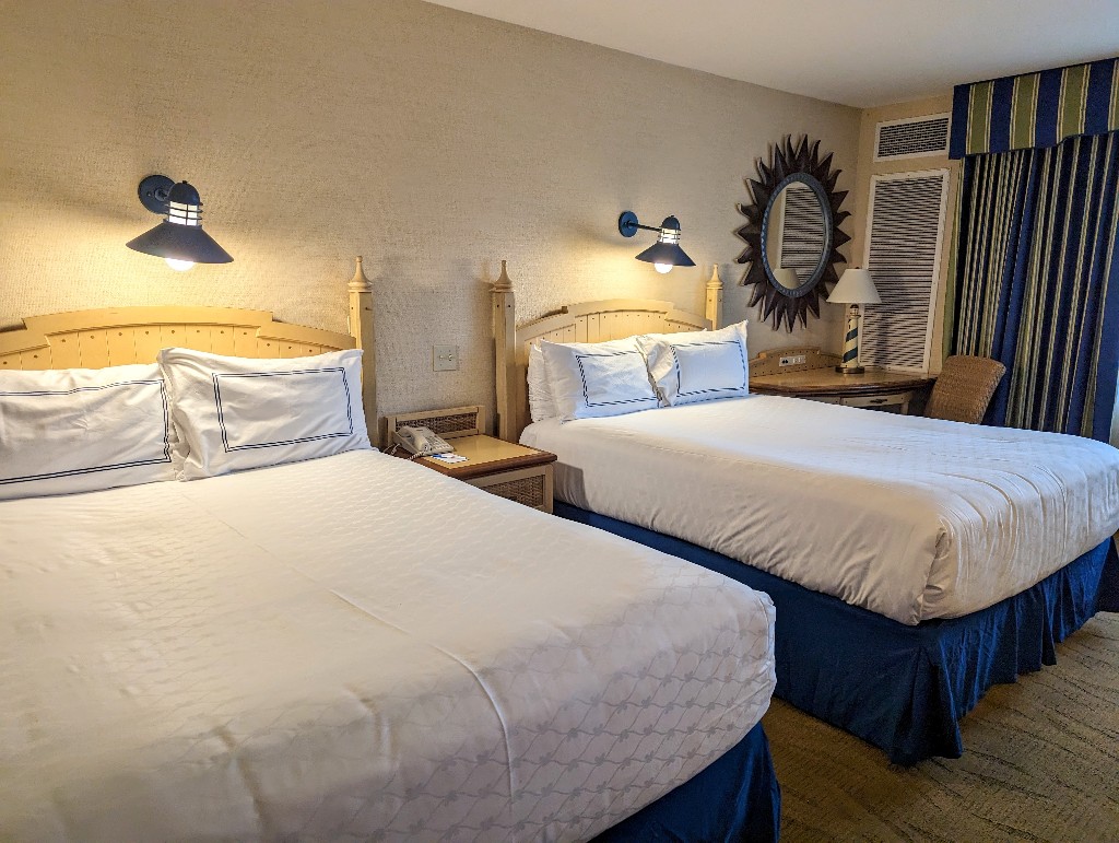 Simple white linens cover the 2 queen beds at Paradise Pier Hotel