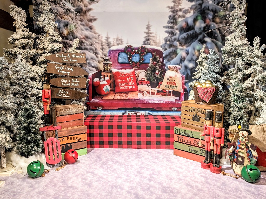 Disney Springs PhotoPass Studio holiday backdrop which looks like an antique snow covered pick up and lots of red and black buffalo check accents