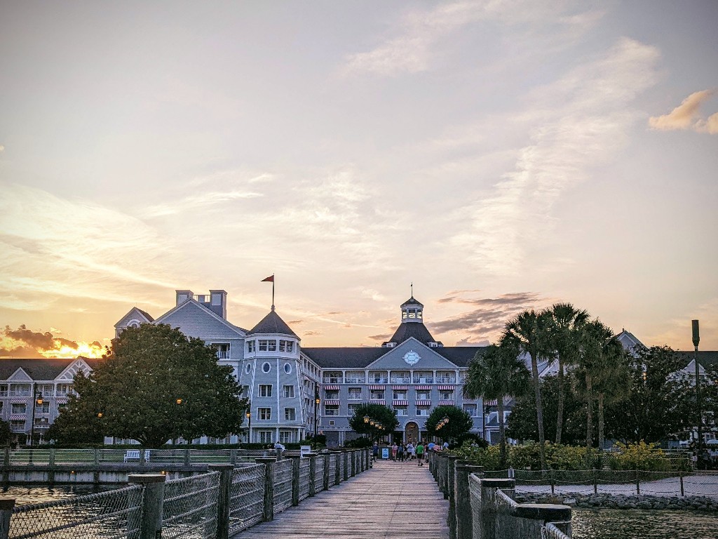A pink and yellow sky frames the iconic Disney Yacht Club resort at sunset