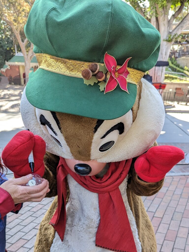 Dale signs a Disney autograph ornament using a special marker at Disneyland