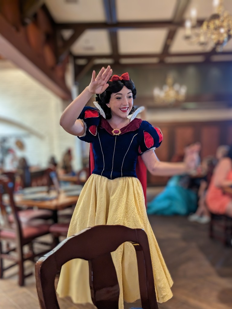 Snow White smiles as waves as the walks around Akershus Royal Baquet Hall at Epcot