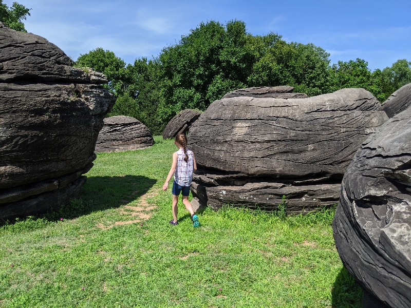 Rock City Park is a great Kansas road trip stop. Stretch your legs and climb huge boulders formed millions of years ago at Rock City. #familytravel #roadtrip #kansas #roadsideattraction