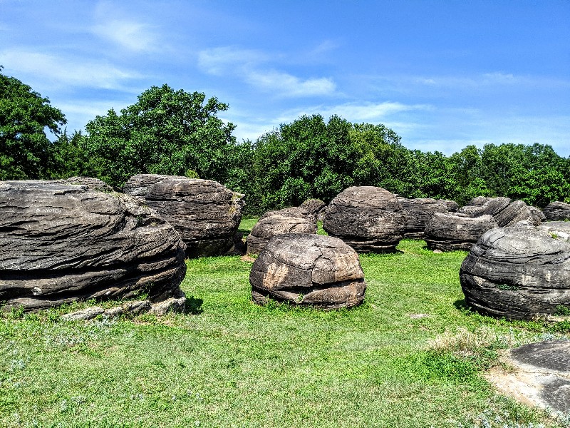 Rock City Park is a great Kansas road trip stop. Stretch your legs and climb huge boulders formed millions of years ago at Rock City. #familytravel #roadtrip #kansas #roadsideattraction