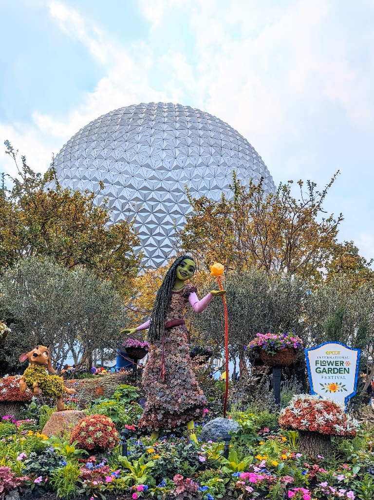 New Asha from Wish topiary at Epcot's main entrance with Spaceship Earth in the background