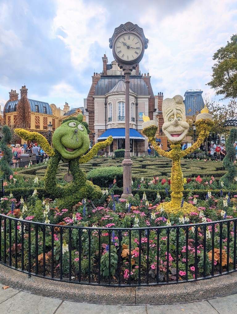 Cogsworth and Lumiere topiaries are eye catching with the France pavilion in the background