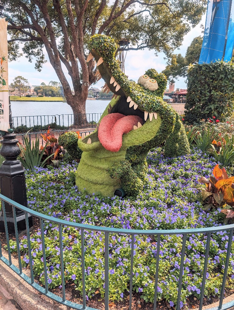 The Tick Tock crock topiary seems to lick his lips in anticipation as he stares at Peter Pan and Hook fighting