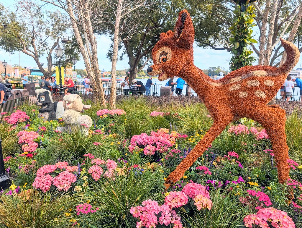 Bambi, Thumper, and Flower prance in a bed of flowers