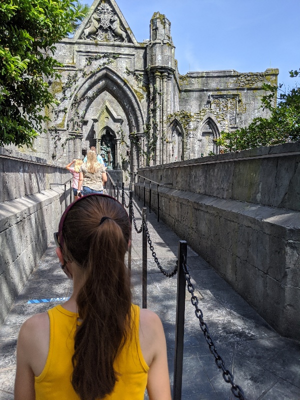 Entrance to Hagrid's Magical Creatures Motorbike Adventure with ornate stone archways. Although still magical, the Wizarding World of Harry Potter during COVID has several changes that you need to know when planning your trip.