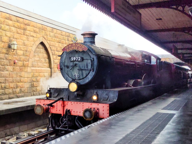 Hogwarts Express train arriving in Hogsmeade station. Although still magical, the Wizarding World of Harry Potter during COVID has several changes that you need to know when planning your trip.