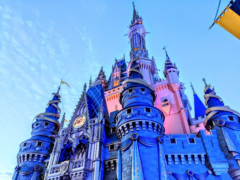 Night time view of Cinderella's Castle at Magic Kingdom. Is it worth it to stay at a Disney World resort? Here's what you should consider before booking a stay off-site for Disney World.