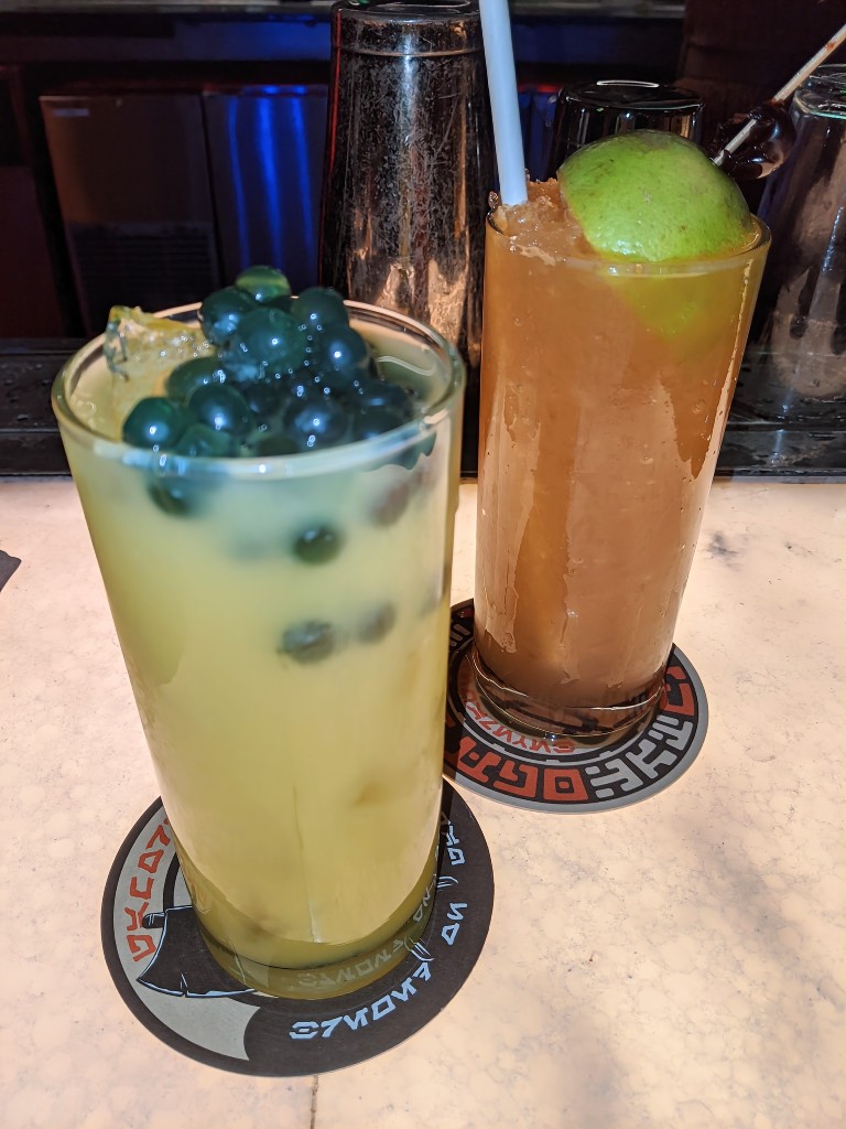Jabba Juice with bright blue popping pearls and Black Spire Brew served with a half lime sit atop Oga's Cantina bar