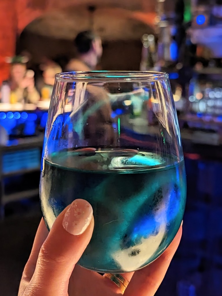 Teal hues Toniray wine sparkles in a stemless wine glass at Oga's Cantina 