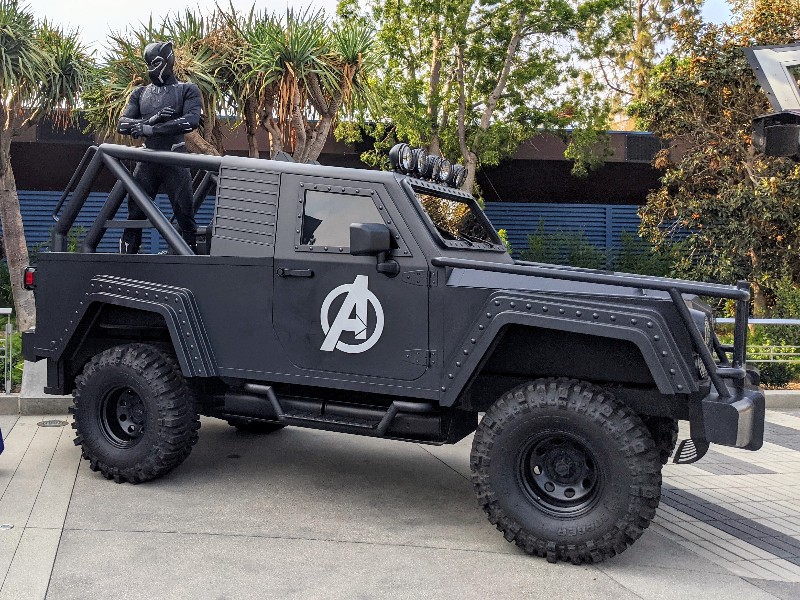 Black Panther perched on back of Avengers vehicle.