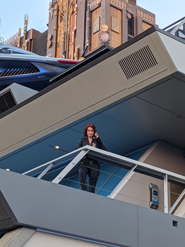 Black Widow waving to guests from Avengers Headquarters at Disney California Adventure.