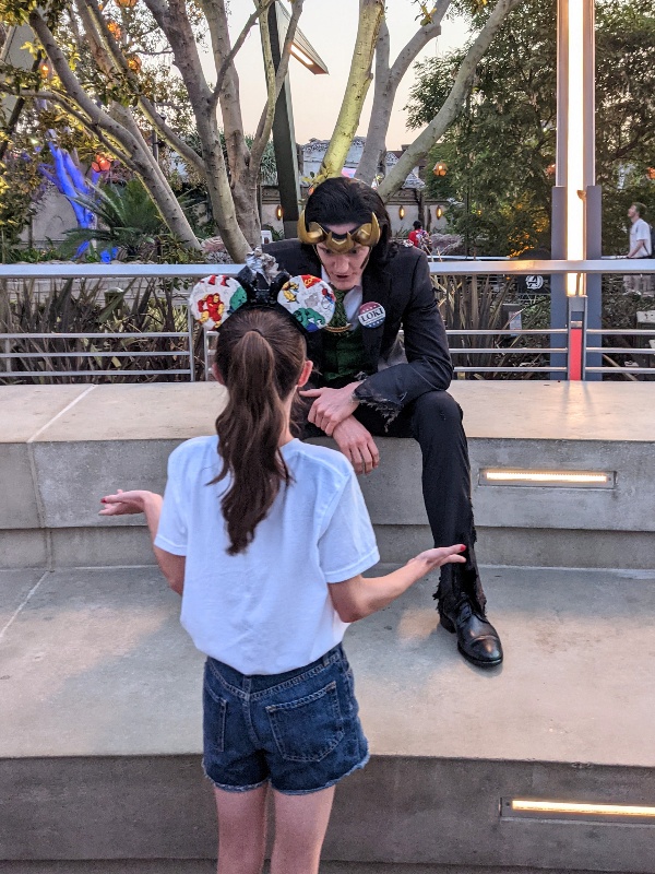 Girl shrugs as Loki asks about the Avengers shirt she is wearing.