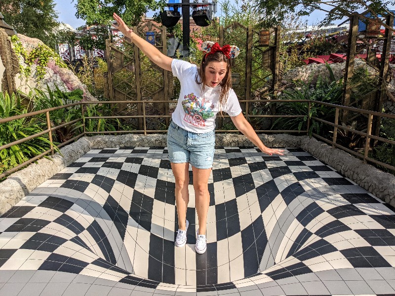 Woman pretends to fall in hole at Avengers Campus in a fun photo op. Avengers Campus seamlessly integrates Marvel characters, cool styling, and unique Avengers Campus rides into your Disneyland vacation.