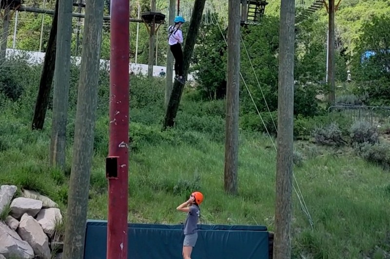 Girl descends from 65 foot high platform on a harness.