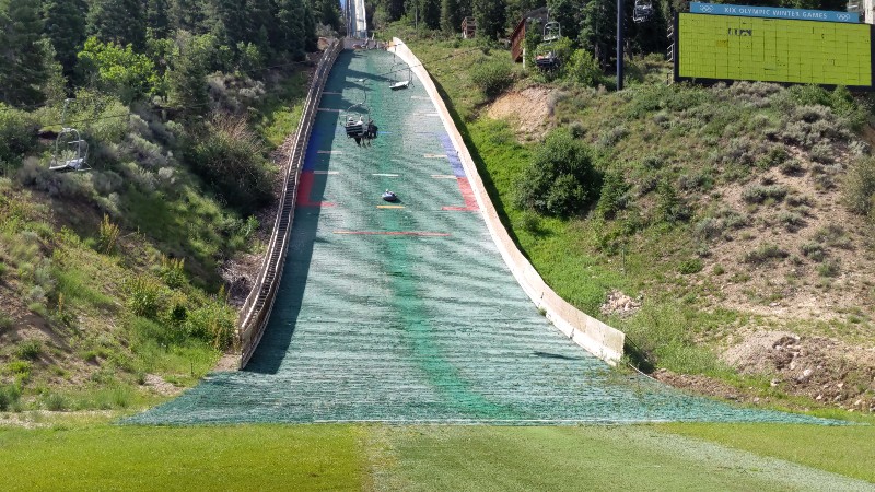 Girl races down Nordic Ski track in an innertube.