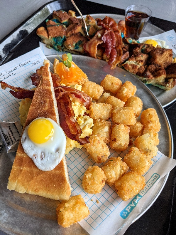 A tiny eggs sits atop focaccia toast and scrambled eggs at Pym Test Kitchen breakfast.