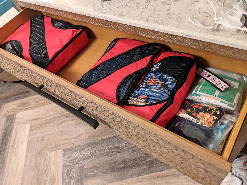 Large drawer open with several packing cubes inside.