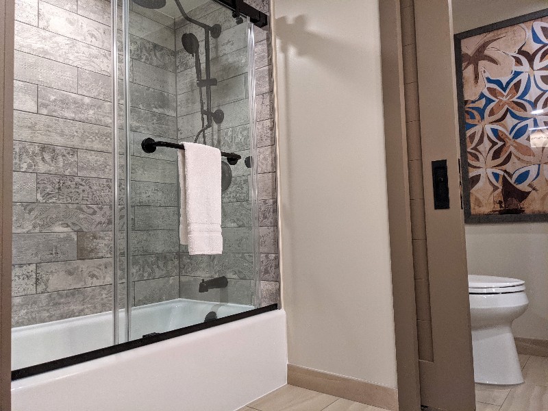 Shower with sliding glass and gray tile