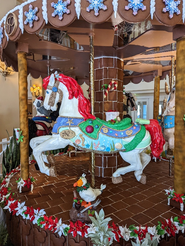 A gingerbread carousel with Little Mermaid themed horses rotates in the lobby of Disney's Beach Club Resort for Christmas