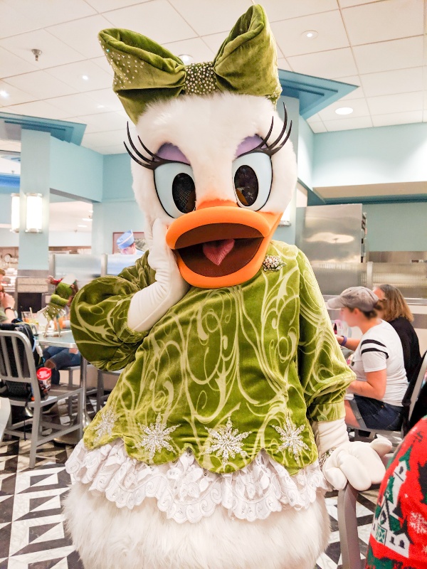 Daisy Duck in a peridot velvet top, matching bow, and stunning accesories at Minnie's Seasonal Dine