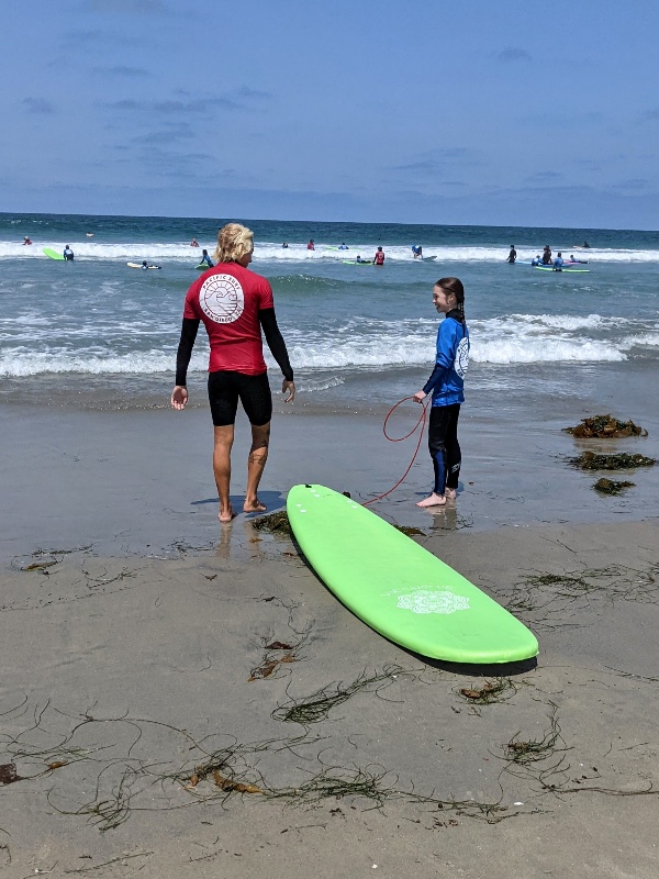 Surf instructor and student take a quick break and discuss technique at Pacific Beach