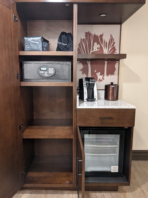 Shelves, a mini fridge, Keurig coffee maker, and in room safe at Disney's Wilderness Lodge