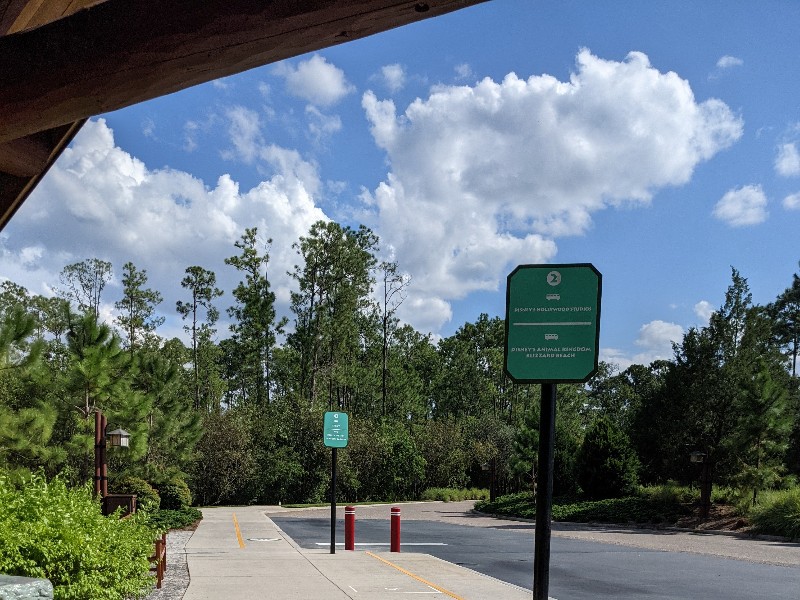 Blue skies above a sign for Disney's Wilderness Lodge Bus stop Hollywood Studios pick up sign