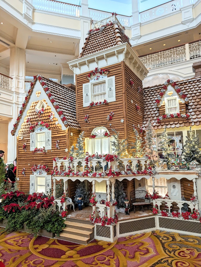 A grand Victorian style gingerbread house has multiple levels, intricate details, and gorgeous decorations on every porch at Grand Floridian Resort