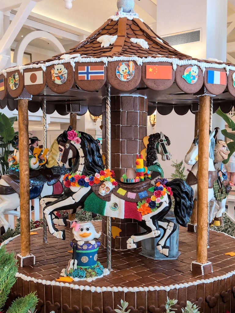A colorful Duck Tales inspired, working gingerbread carousel at Disney's Beach Club Resort features three differently decorated horses