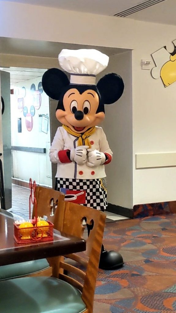 Chef Mickey in his crisp white chef's coat, toque, and checkered apron greets guests at this Disney World character meal