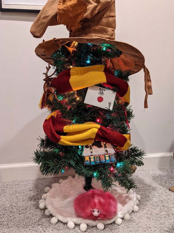A sorting hat tree top, Gryffindor scarf, and Harry Potter inspired ornaments on our mini Hogwarts Christmas tree
