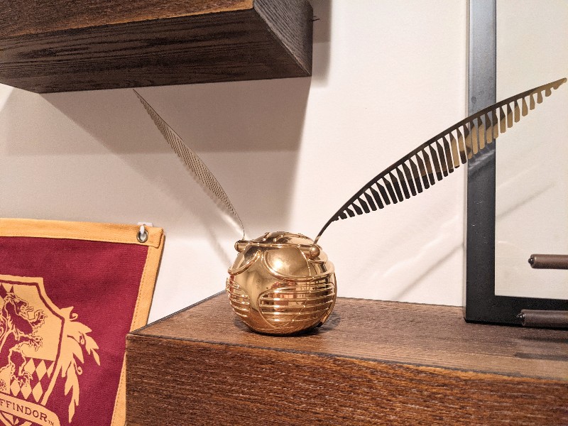 A golden snitch clock provides the time and stylish decor