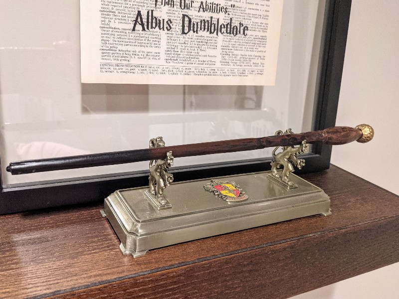 A Wizarding World of Harry Potter interactive wand sits upon a Gryffindor wand stand in our Harry Potter inspired room