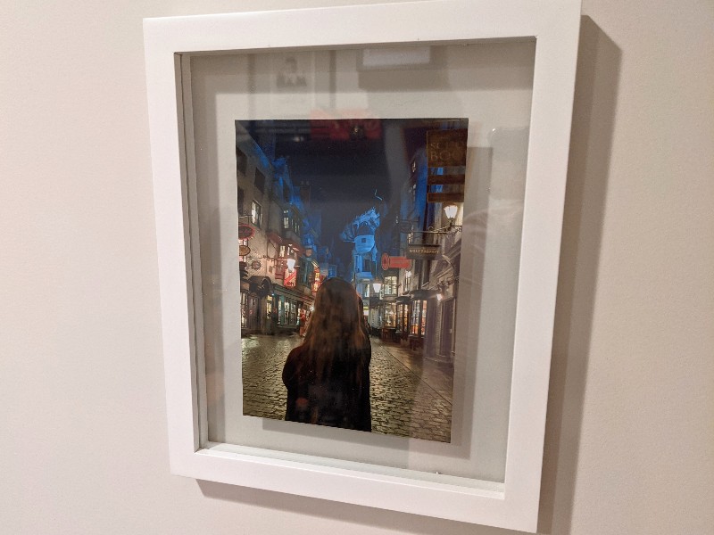 A framed photo of a girl pointing her wand towards Gringotts in Diagon Alley