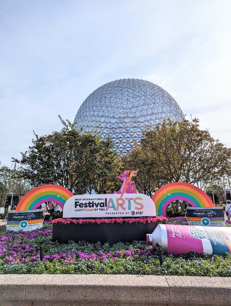 Spaceship Earth looms behind the Festival of the Arts welcome sign