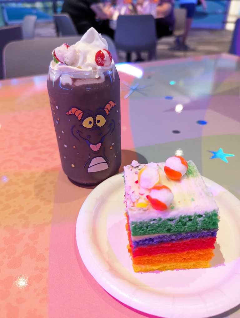 Grape smoothie in a Figment themed cup and a rainbow cake both sprinkled with freeze dried Skittles at Figment's Inspiration Station