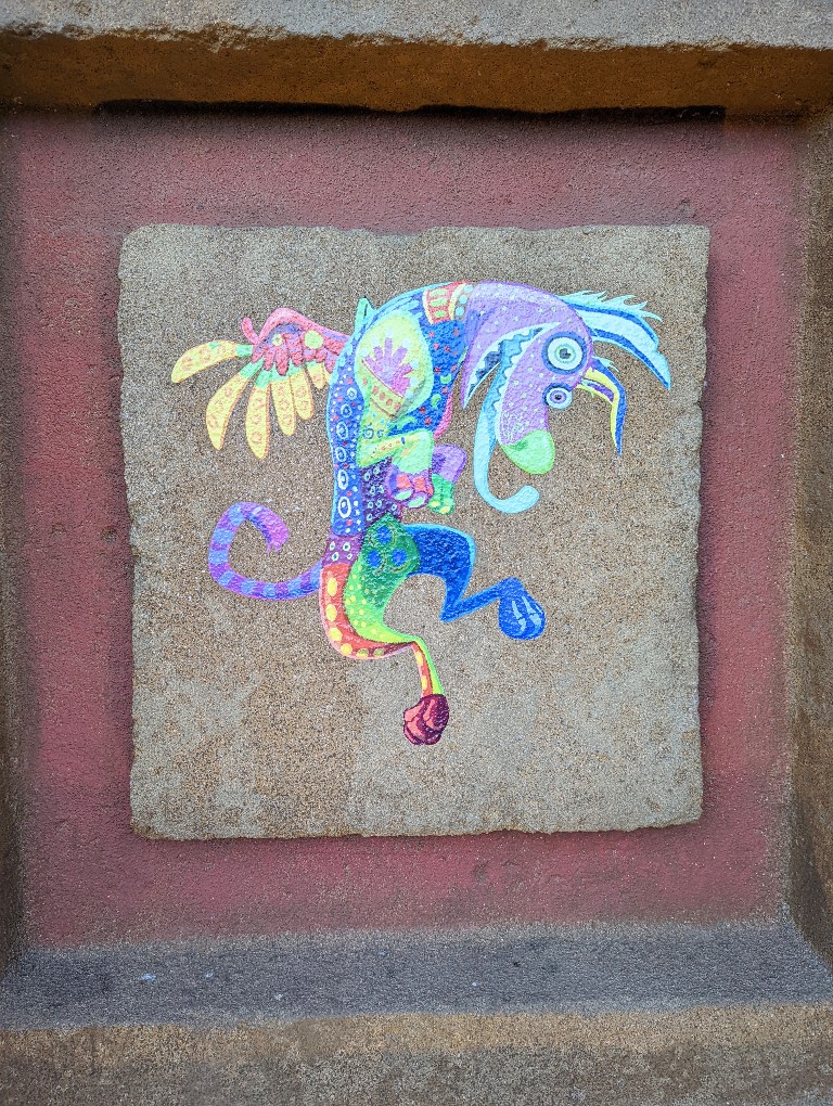 Chalk drawing of Dante from Coco on the side of Mexico pavilion pyramid