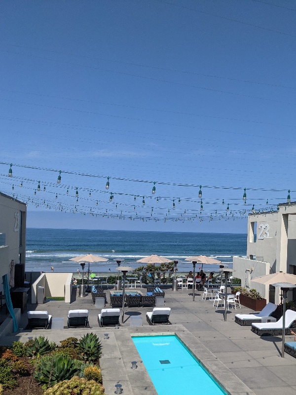 Views of blue skies above the ocean in the distance and the sleek Tower 23 patio