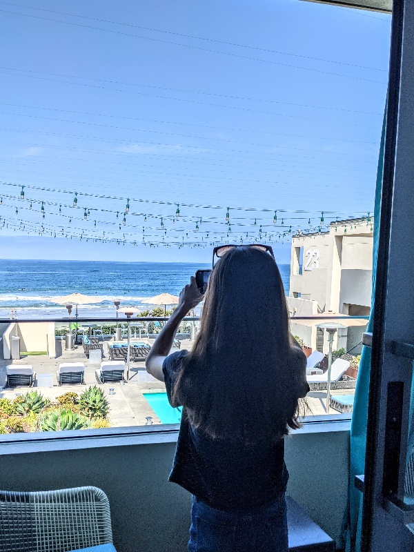 Girls takes a picture of the stunning ocean view from Tower 23 balcony