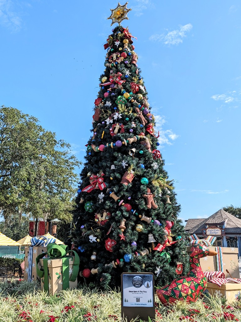 Once Upon a Toy Christmas tree strung with toys, colorful baubles, and gifts surrounding the base