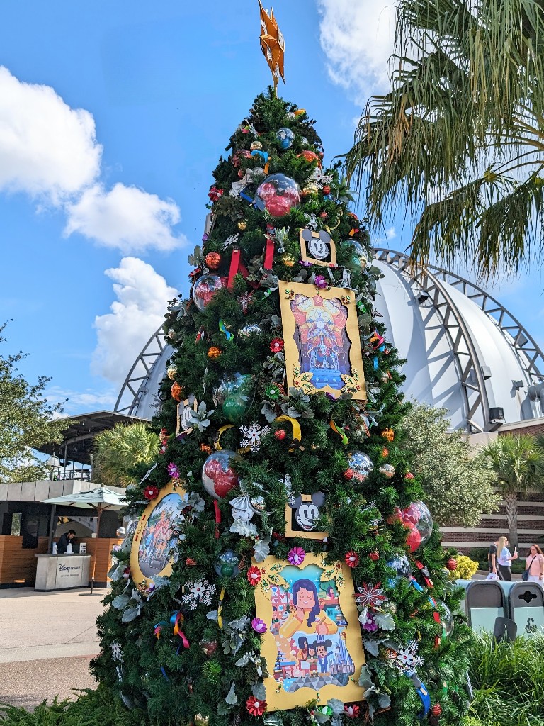 A bright yellow star, Disney Passholder ornaments that look like the magnets, and cartoon scenes of families at Disney make this a charming tree