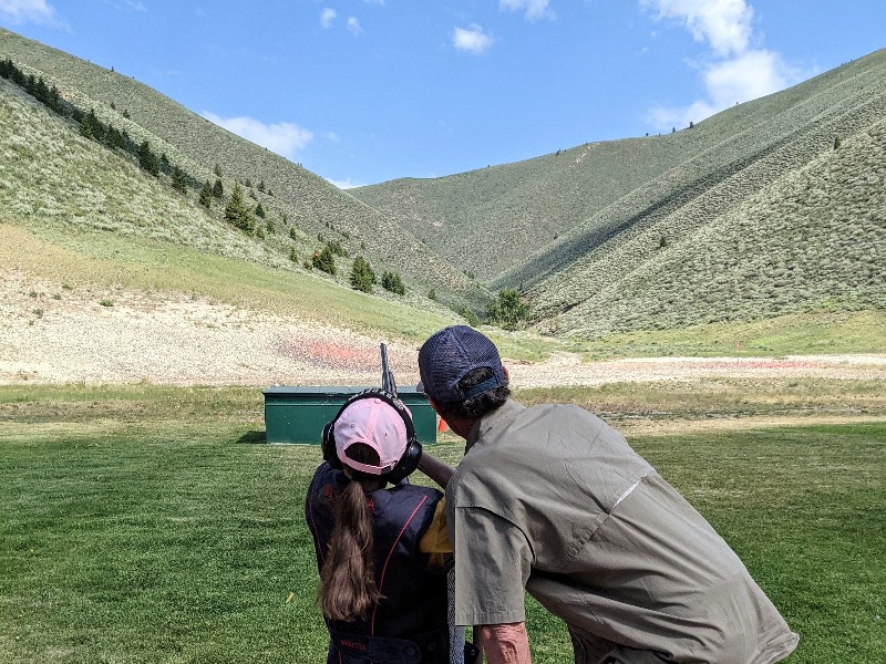 Girl takes aim at target under guidance of an instructor at Sun Valley Gun Club