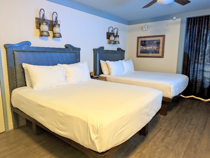 Blue headboards with lantern style lights over a crisp white bed