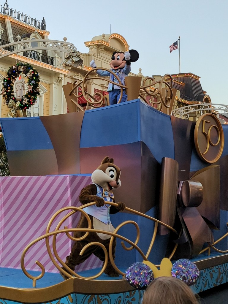 Mickey and Chip wave to guests from a Magic Kingdom cavalcade