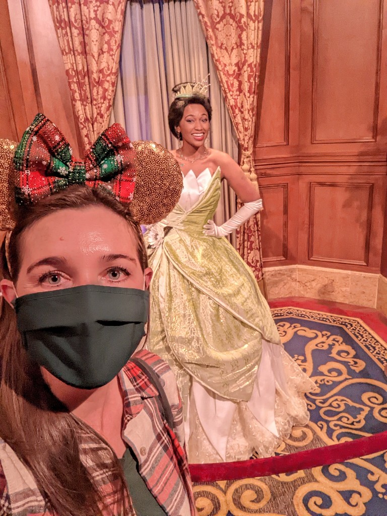 Woman takes a masked selfie with Princess Tiana at Disney World